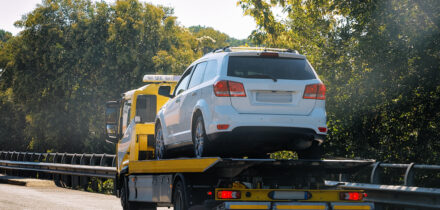 Tow truck with car on road