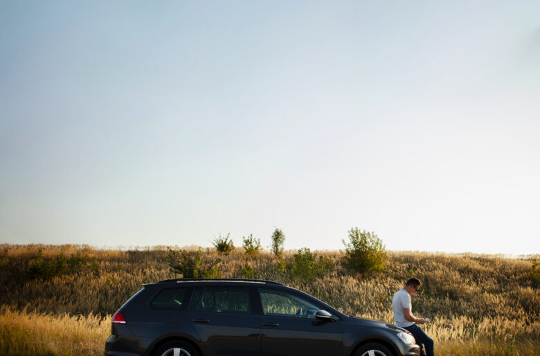 man-sitting-car-hood