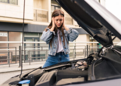 Young worried girl of the mechanic the problem with a car